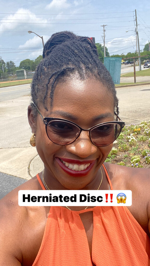 Photo of Dr. Folake smiling, wearing glasses. Captioned Herniated Disc